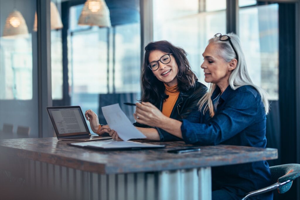 woman helping other woman with paperwork