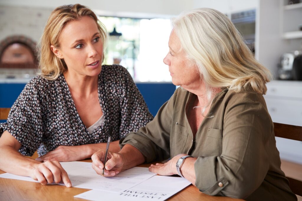 woman helping other woman with paperwork